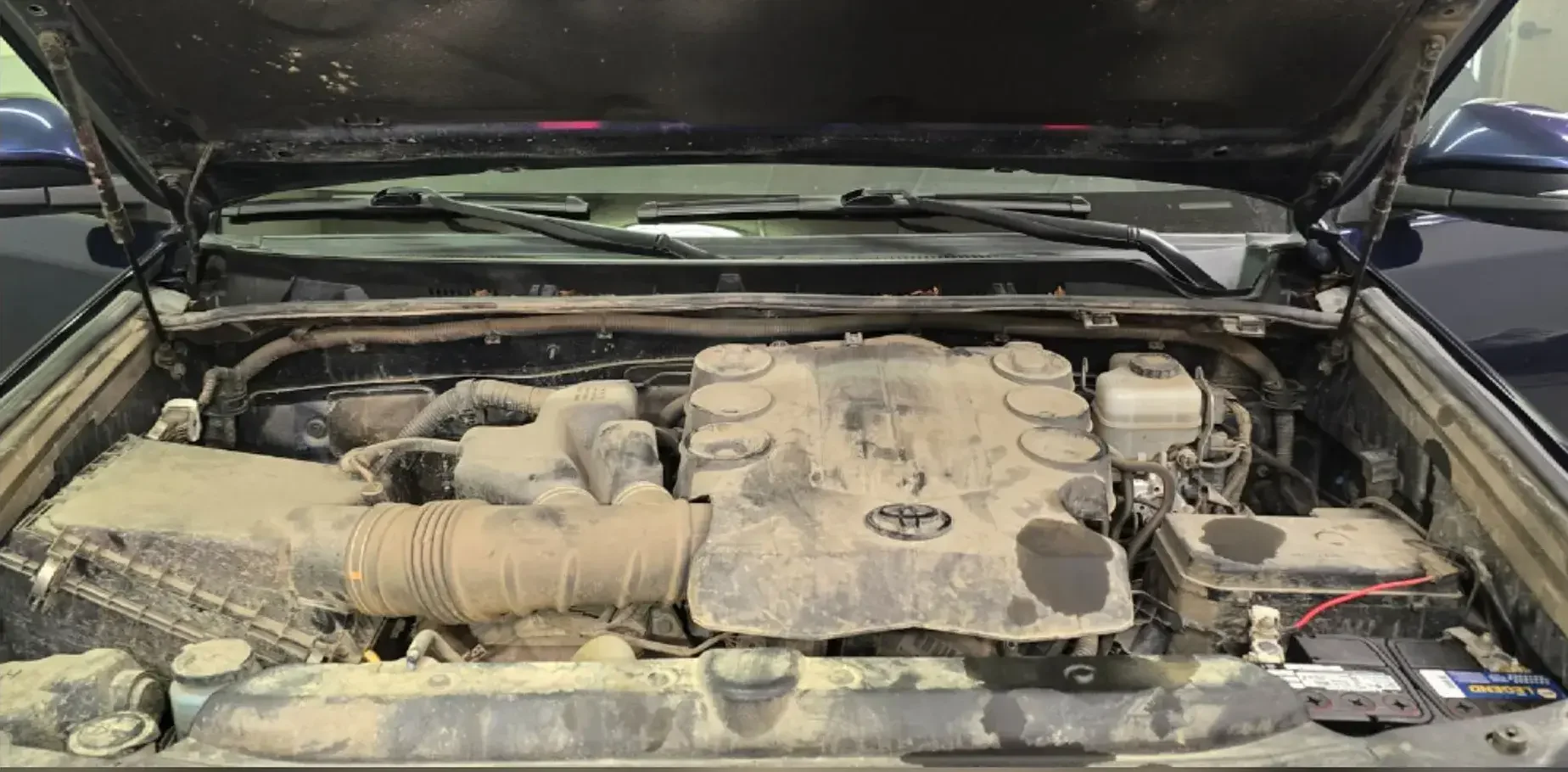 Toyota 4Runner engine bay caked with dirt and dust before engine bay cleaning