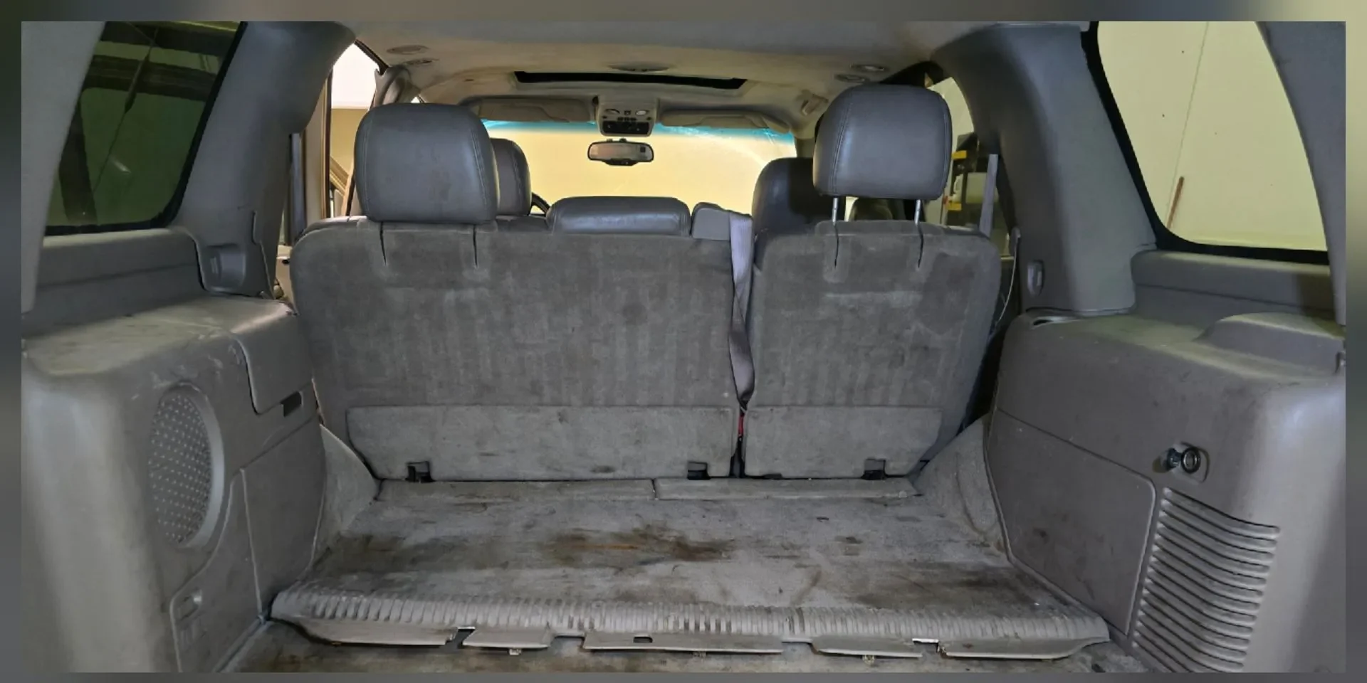 Neglected SUV cargo area with heavy staining and contamination before deep interior cleaning