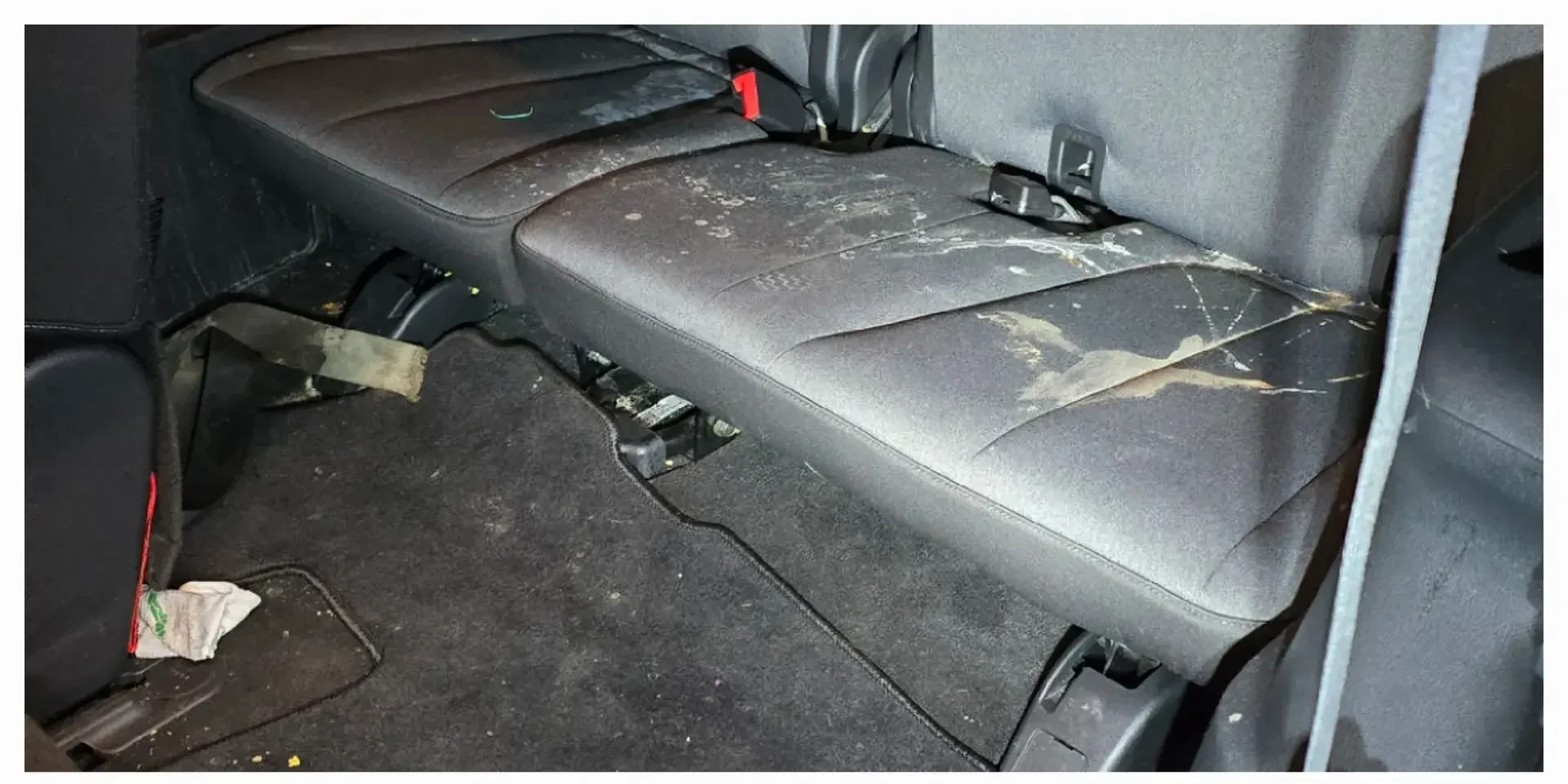 SUV rear bench seat with spills, staining and debris before odor and stain removal in Anchorage, Alaska