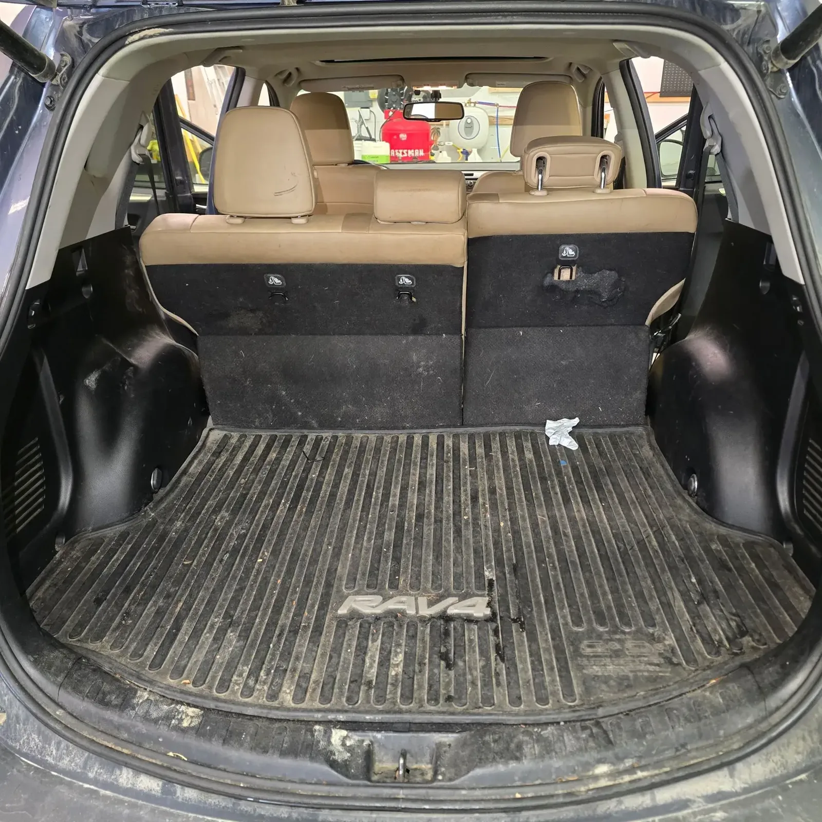 Toyota RAV4 cargo area with dusty liner and debris before interior detailing