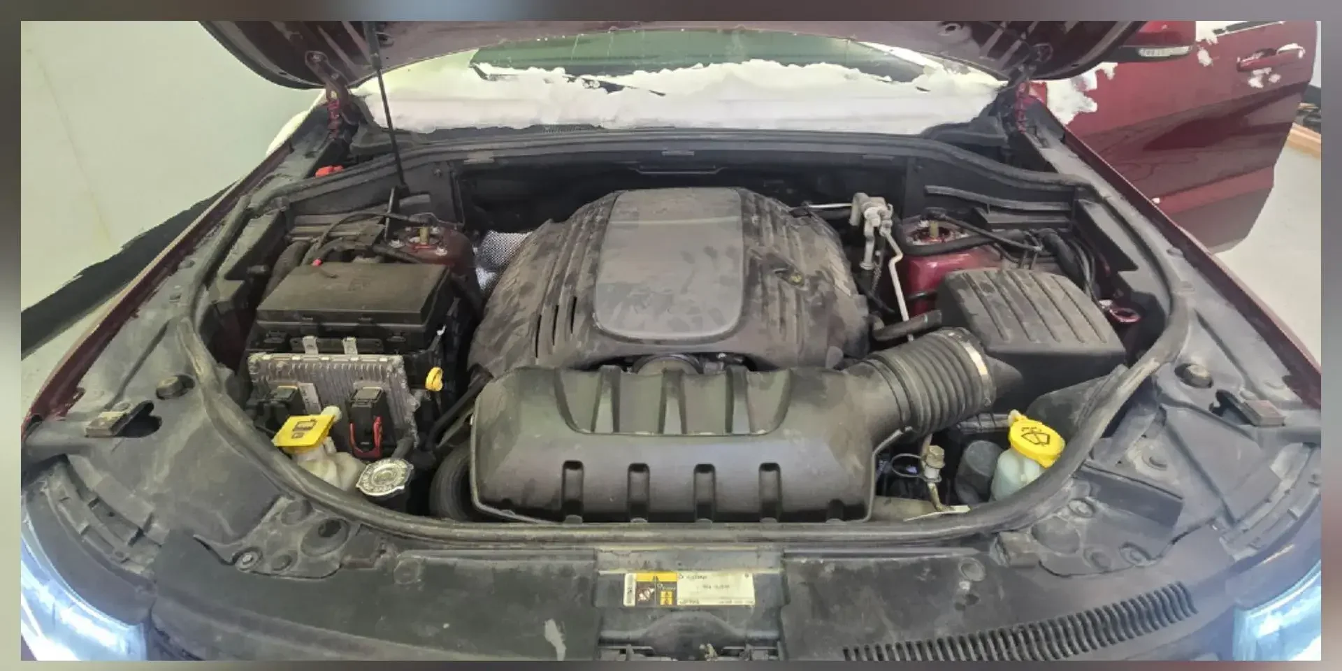 Jeep Grand Cherokee engine bay with heavy dust and grease buildup before cleaning in Anchorage, Alaska