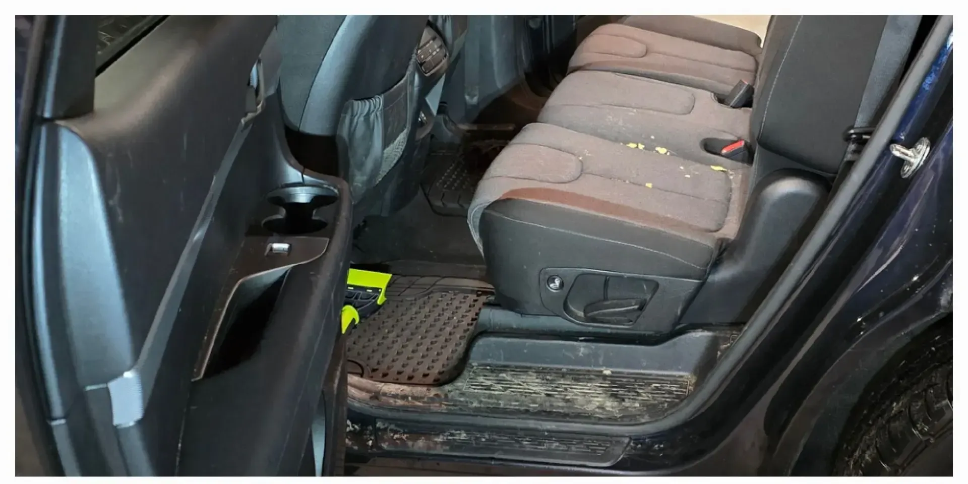 Rear seats and door sill with dirt and debris before interior detailing in Anchorage, Alaska