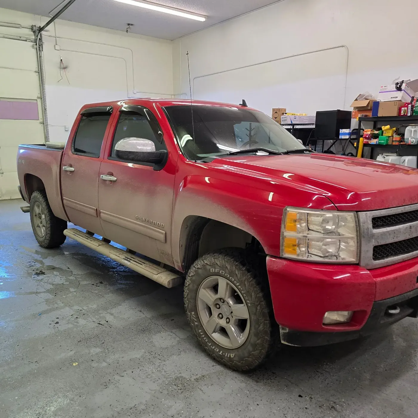 Red Chevrolet Silverado dulled by dirt and road grime before a full detail